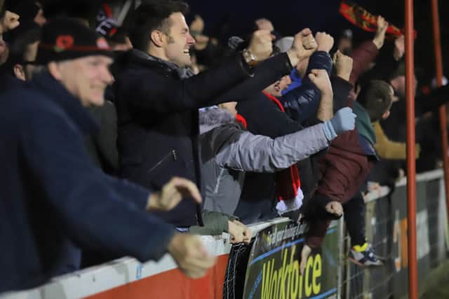 The Poppies supporters show their delight after the late equaliser