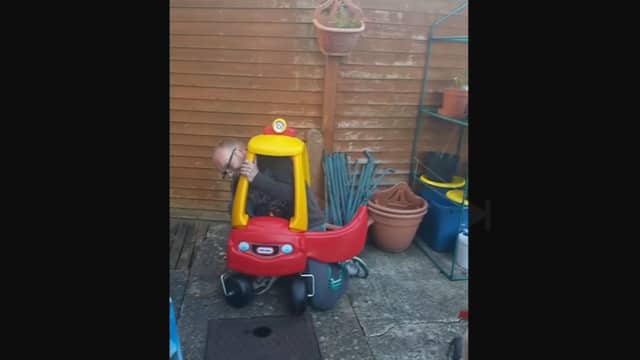 A dad finds it impossible to get out of his toddler's Little Tikes car.