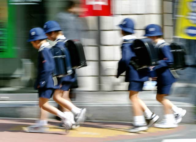 This photo taken 22 April 2004 shows schoolchildren making their way home from class in Tokyo. Photo by YOSHIKAZU TSUNO/AFP via Getty Images