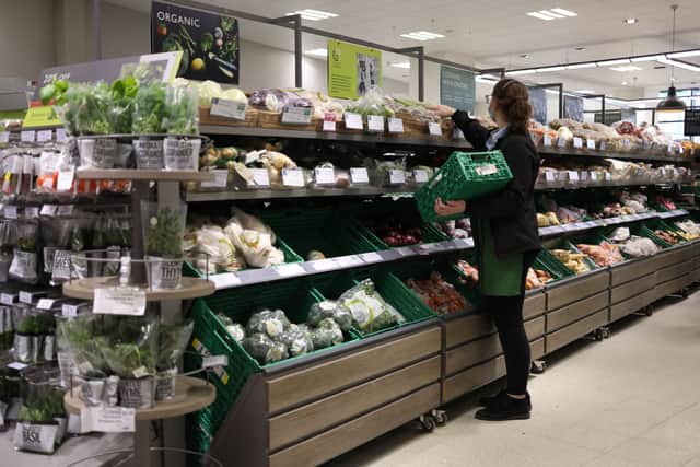 An employee stacks shelves at a Waitrose supermarket in London (Photo: HOLLIE ADAMS/AFP via Getty Images)