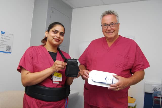 Staff nurse Minu John holds the old-style bulky monitor and Dr Andrew Dixon holds the new stick-on version in its packet (opening the packaging starts the recording so we have kept the packaging on).