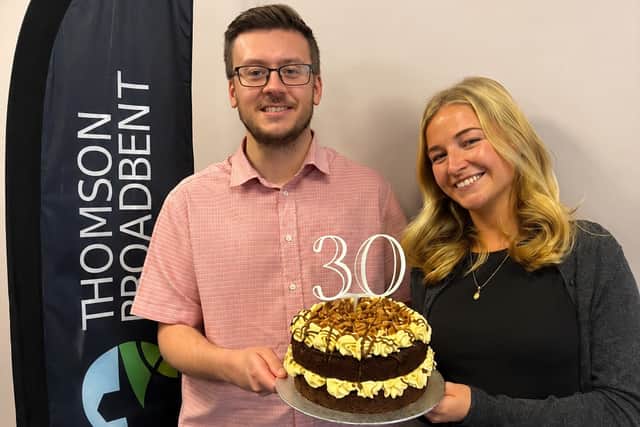 Team members Dylan Connellan and Maddy Leebrook with the delicious 30th birthday cake baked to celebrate Thomson Broadbent's birthday