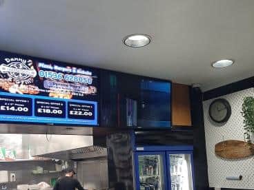 The TV to the right of the sign, above the fridge, was smashed
