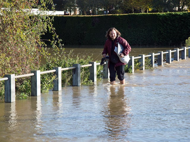 One passer-by rolled his trousers and removed his shoes to make it through the water.