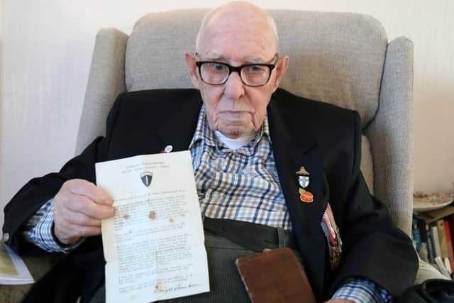 Jim holds his service book and the letter given to all soldiers, sailors and airmen from General Einsenhower, Supreme Commander of Allied Expeditionary forces during Operation Overlord.