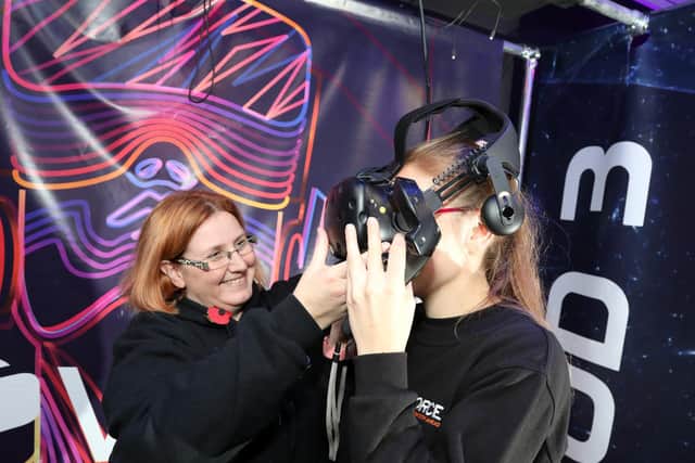 Lynnette helps a customer put on the headset
