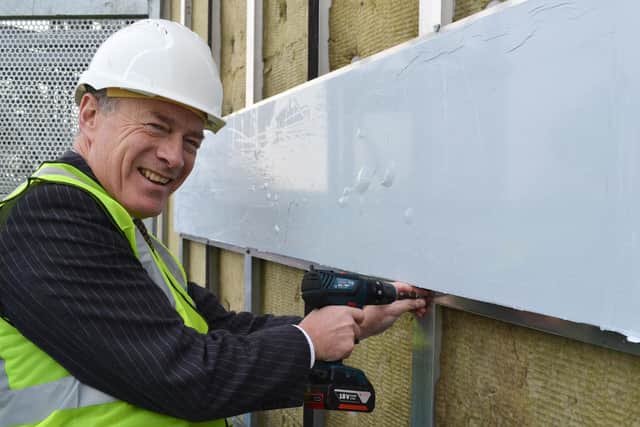 Ian Pryce attaching the first cladding panel.