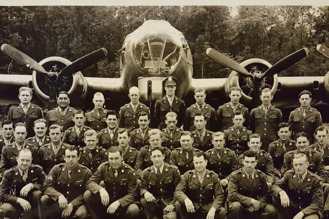 Clark Phillips (bottom row, far right) poses proudly for a photo in front of one of the  a B-17 'Flying Fortress' bombers based at Grafton Underwood
