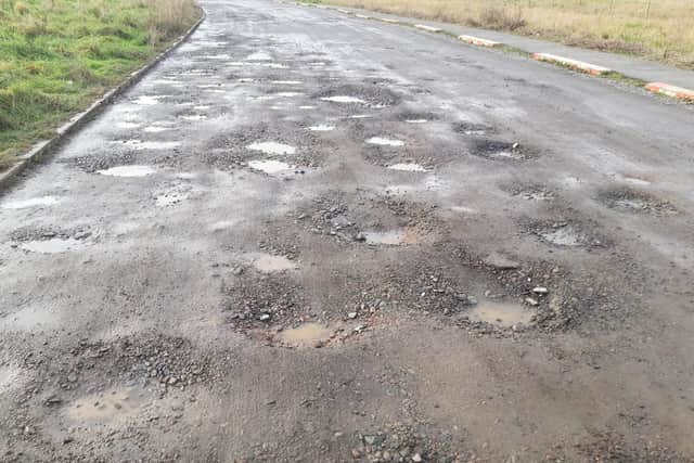 Dozens of potholes line the road.