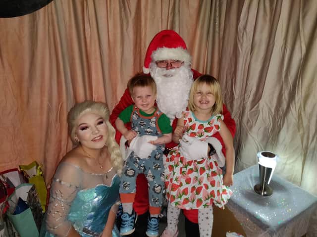 Lukas visiting Santa and 'Elsa' with his sister, Elisia
