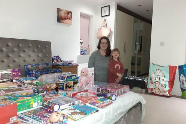 Cat Schofield with daughter Evelyn with some of the presents given out last Christmas
