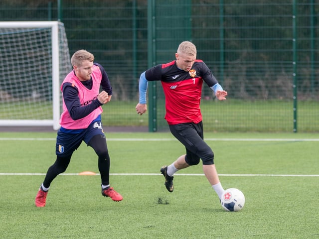 Lindon Meikle gets on the ball with Jason Law in close attendance