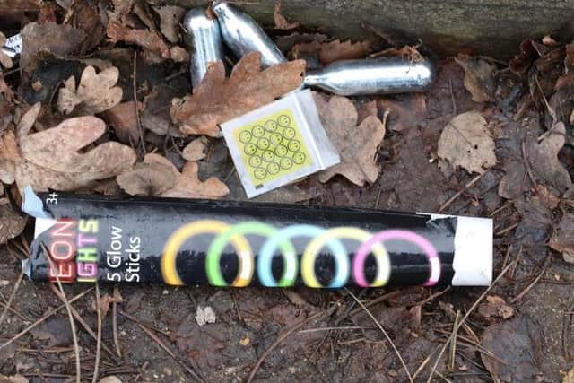 Empty nitrous oxide canisters and a discarded drugs bag with glow sticks outside the site of an illegal rave at new year in Corby
