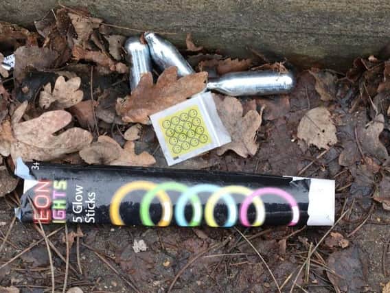 Empty nitrous oxide canisters and a discarded drugs bag with glow sticks outside the site of an illegal rave at new year in Corby