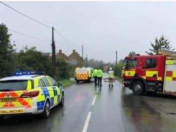 Police and fire crews wait in the rain while the package in Litchborough is dealt with