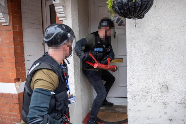 Police armed with a warrant force their way into a property in Northampton last week: Photos Northamptonshire Police