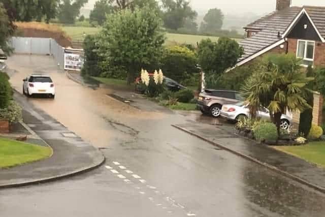 The flood water ran down on the Spencer's driveway (right).