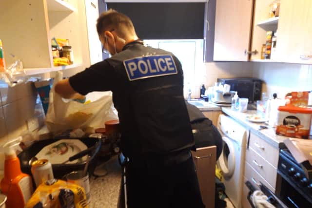 Police search the kitchen for drugs and weapons.