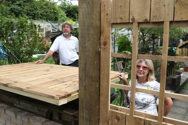 ..a socially distanced dining table. The couple already had a window cut in their fence.