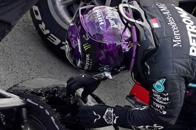 Hamilton inspects damage to the tyre that nearly cost him victory. Photo: Getty Images