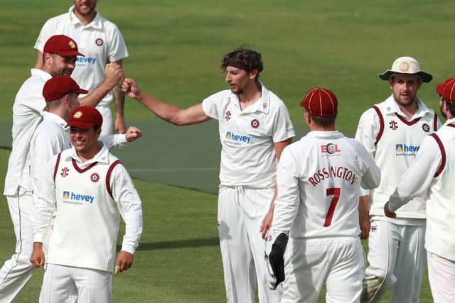 Jack White accepts the plaudits from his Northants team-mates after claiming the wicket of Worcestershire's Daryl Mitchell for 39