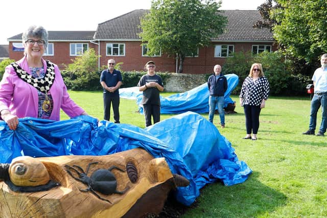Mayor Councillor Tina Reavey lifts the covers off one bench watched by Dave Marlow from Highways England; Carrie Yuen, Phil Keane, Group Operations Manager (East) for contractor Carnells, local resident Justina Bryan and Jeremy Willis, Construction Manager for contractor Ground Control.