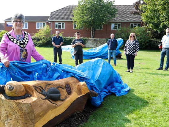 Mayor Councillor Tina Reavey lifts the covers off one bench watched by Dave Marlow from Highways England; Carrie Yuen, Phil Keane, Group Operations Manager (East) for contractor Carnells, local resident Justina Bryan and Jeremy Willis, Construction Manager for contractor Ground Control.