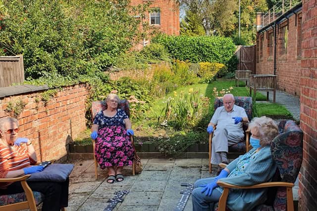 Visitors at Kettering's Age UK day care centre playing floor dominos