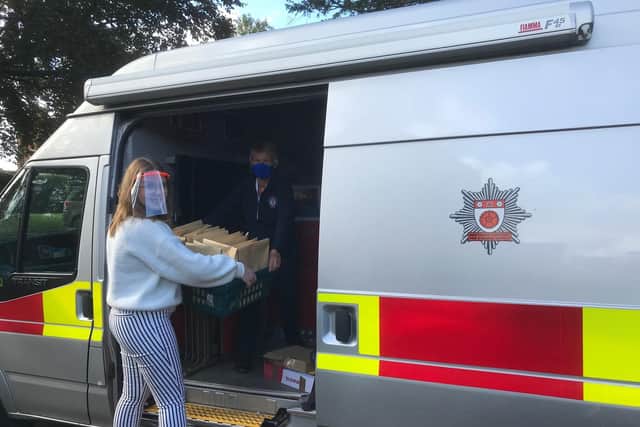 Volunteer with Northamptonshire Fire and Rescue Service loading up Greetings From... packs as part of the distribution effort