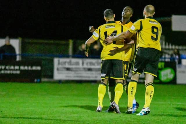 Lorrell Smith takes the congratulations from Jesse Akubuine and Tom Lorraine after he scored Diamonds' second equaliser from the penalty spot