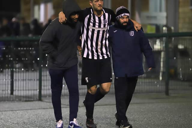 Charlie Wise is helped away from the pitch after suffering an ankle injury
