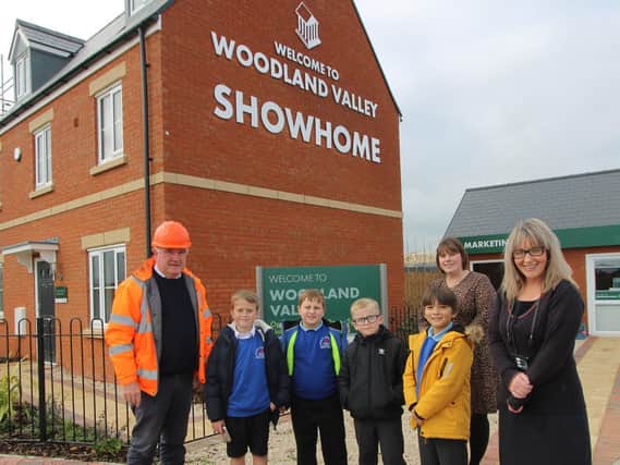 Persimmon Homes Midlands site manager Jim Wilkinson, sales manager Dawn Ward and sales advisor Louise Derrick with their Rothwell Junior School visitors at Woodland Valley.