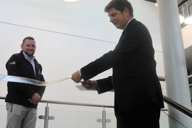 CEO Dr Andrew Campbell cuts the ribbon, watched by Allun O’Brien, Senior Build Manager at Willmott Dixons.