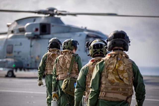 Crew boarding a Merlin MK2 helicopter on HMS Queen Elizabeth
