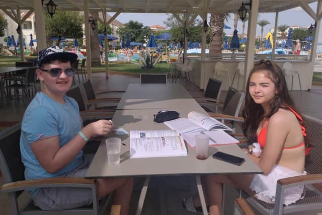 James Connelly, 15, and his cousin Jessica, 15, revising for their mock GCSEs by the pool. COPYRIGHT: The Connelly and Hayes families.