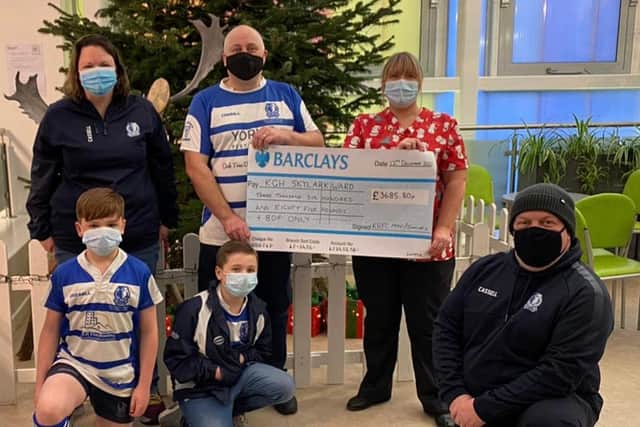 Players and representatives hand over the cheque.