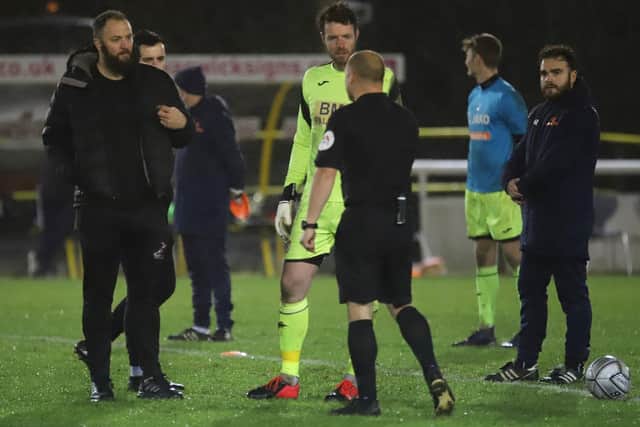 Poppies goalkeeper Adam Collin talks to referee Adrian Quelch ahead of the second half at Leamington which started just after 10.30pm