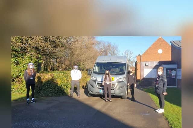 Staff with the minibus used to deliver items.