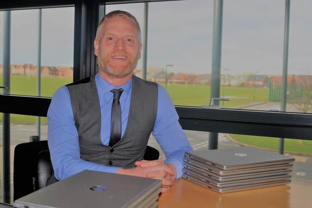 Simon Underwood with some of the donated laptops.