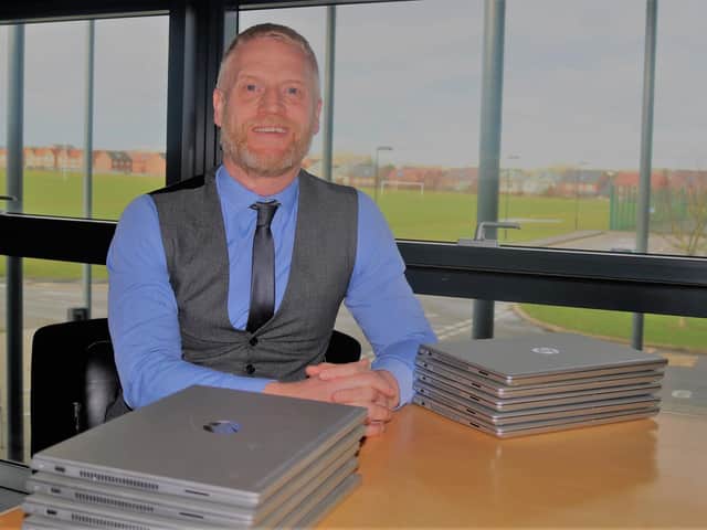 Simon Underwood with some of the donated laptops.