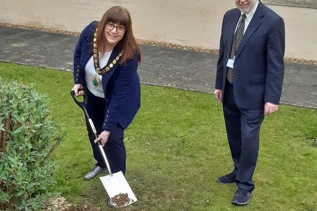 Cllr Helen Howell and chief executive David Oliver burying the time capsule