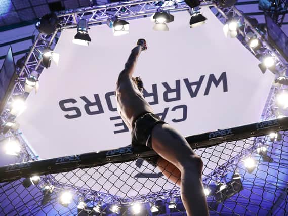 Jordan Vucenic celebrates at the top of the cage after he became the Cage Warriors featherweight champion. Pictures by Dolly Clew (www.dollyclew.com)
