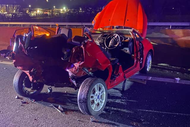 Firefighters cut the driver out of this Ford after last night's smash which closed the M1 in Northamptonshire