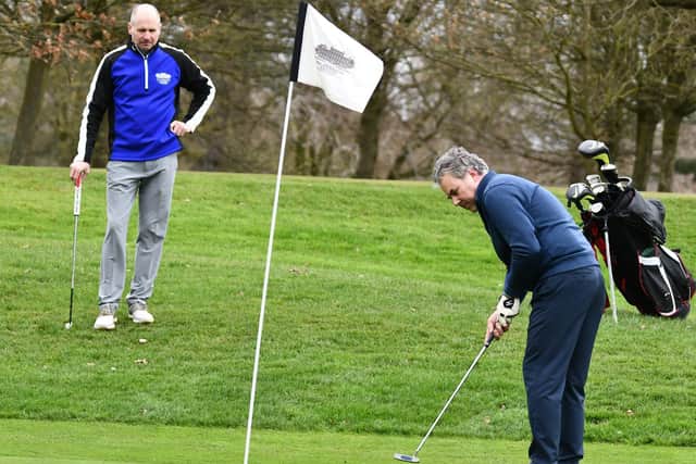 Paul Albery putts while Giovanni Gioia watches on during the first day back for local golfers