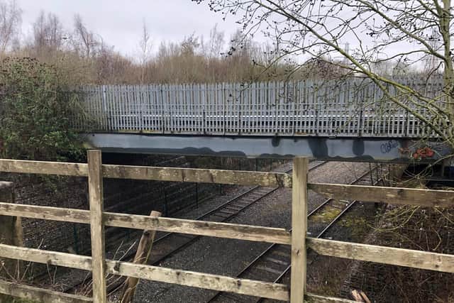 The railway bridge is protected in parts only by a wooden fence