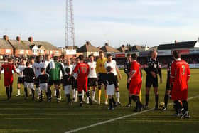 The Kettering Town and Fulham players exchanging handshakes ahead of their FA Cup fourth round tie at Rockingham Road in 2009