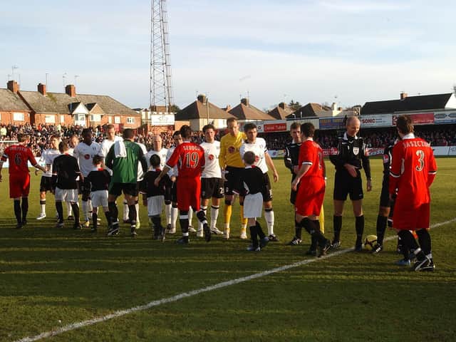 The Kettering Town and Fulham players exchanging handshakes ahead of their FA Cup fourth round tie at Rockingham Road in 2009
