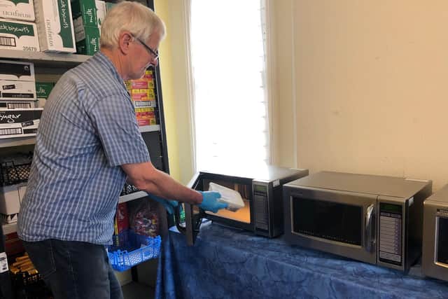 Daylight Centre Fellowship trustee James Bellamy, who is also acting as a volunteer, microwaves a frozen meal