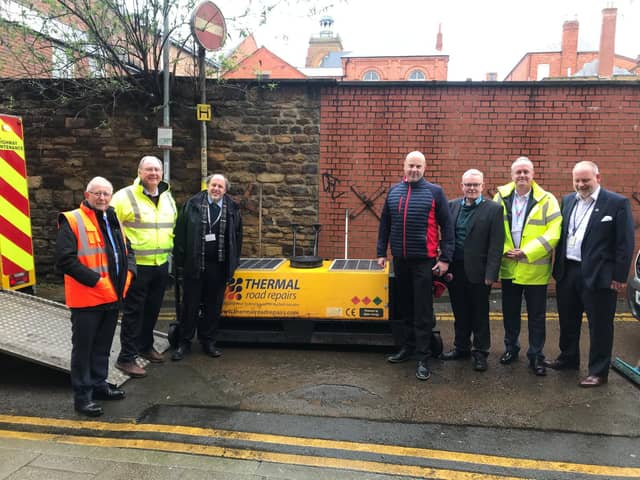 Councillors are pictured with one of the new thermal repair machines.
