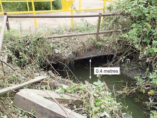Debris was trapped under this bridge, blocking water from leaving the balancing lakes
